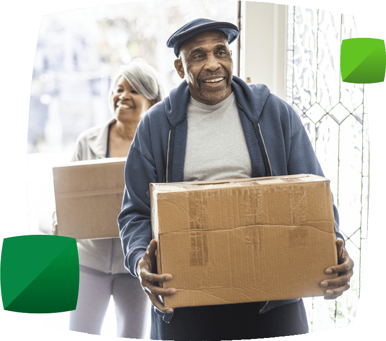 older couple carrying boxes through doorway