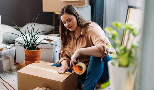 Woman sealing box with packing tape