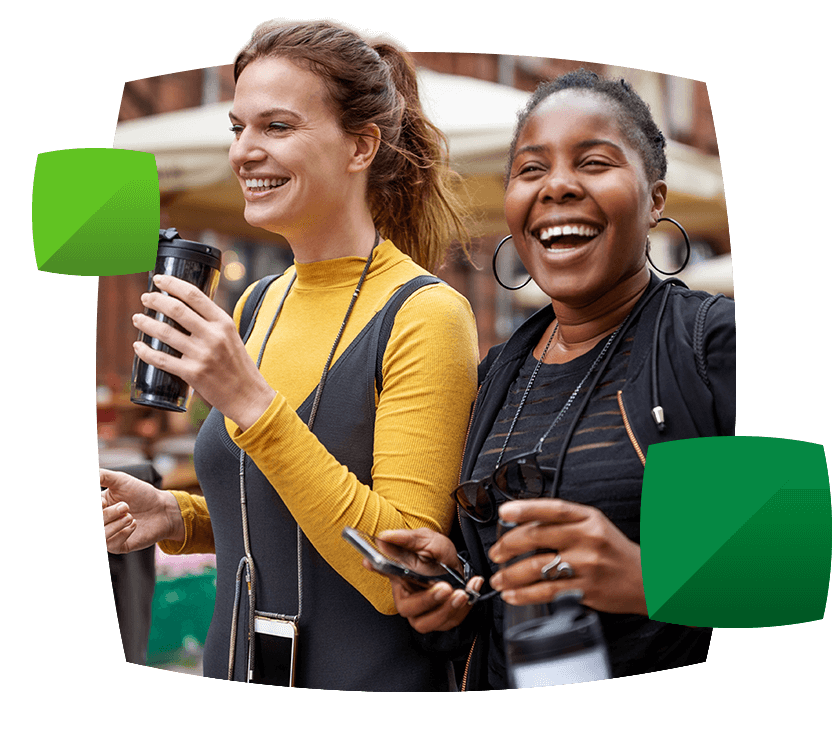 Women with holding a drink and a phone having fun